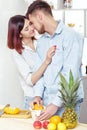 Happy couple in love in kitchen making healthy juice from fresh orange. couple is kissing Royalty Free Stock Photo