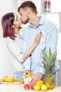 Happy couple in love in kitchen making healthy juice from fresh orange. couple is kissing Royalty Free Stock Photo