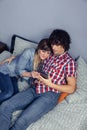 Happy couple in love looking electronic tablet on bed