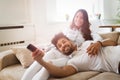 Happy couple lying on sofa together and relaxing at home Royalty Free Stock Photo