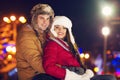 Happy couple in love outdoor in evening Christmas lights