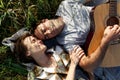 Happy couple in love on a romantic date at the park on a picnic. Playing on a guitar and having fun outdoors. Top view Royalty Free Stock Photo