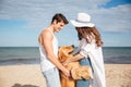 Happy couple in love sitting on the beach with dog Royalty Free Stock Photo