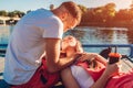 Happy couple in love sitting by the river, hugging and kissing Royalty Free Stock Photo