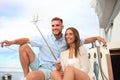 Happy couple in love taking selfie on sailing boat, relaxing on a yacht at the sea. Royalty Free Stock Photo