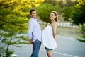 Happy couple in love together in park landscape on sunset with woman pregnant belly and man Royalty Free Stock Photo