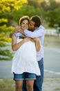 Happy couple in love together in park landscape on sunset with woman pregnant belly and man Royalty Free Stock Photo