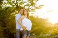 Happy couple in love together in park landscape on sunset with woman pregnant belly and man Royalty Free Stock Photo