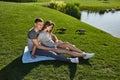 Happy couple in love waiting for child pregnancy hug summer green trees sitting on the grass rest nature husband wife baby family Royalty Free Stock Photo