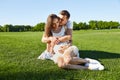 Happy couple in love waiting for child pregnancy hug in the summer park green trees sitting on the grass rest nature husband wife