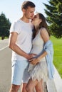 Happy couple in love waiting for child pregnancy hug walk in the summer park green trees nature husband and wife baby boy young