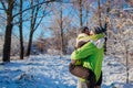 Couple in love walking and hugging in winter forest. Man holding girlfriend and kissing. Young people having fun Royalty Free Stock Photo