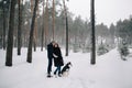 Couple in love walking with Husky in winter forest Royalty Free Stock Photo