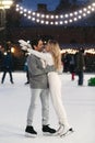 Happy couple of lovers having fun, hugging at ice skating rink outdoor. St. Valentines Day, Winter Royalty Free Stock Photo