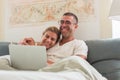 Happy couple lying in bed and looking at laptop screen Royalty Free Stock Photo