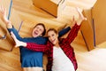 Happy couple lying on the floor in new home with cordboard boxes around Royalty Free Stock Photo