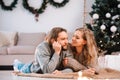 Happy couple lying on the floor of their house decorated for christmas. Royalty Free Stock Photo