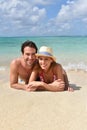 Happy couple lying on sandy beach Royalty Free Stock Photo