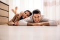 Happy couple lying on warm floor at home. Heating system Royalty Free Stock Photo