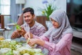 happy couple making ketupat for idul fitri