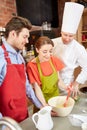 Happy couple and male chef cook cooking in kitchen Royalty Free Stock Photo