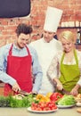 Happy couple and male chef cook cooking in kitchen Royalty Free Stock Photo