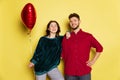 Happy couple, man and woman holding balloons shaped hearts and gift box. Valentine& x27;s day celebration. Concept of Royalty Free Stock Photo