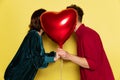 Happy couple, man and woman holding balloons shaped hearts. Valentine& x27;s day celebration. Concept of emotions, love Royalty Free Stock Photo