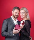 Happy couple of man and woman holding gift boxes presents for Valentines day red background Royalty Free Stock Photo