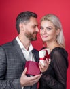 Happy couple of man and woman holding present boxes presents for Valentines day red background Royalty Free Stock Photo