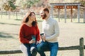 Happy couple man and woman in love sitting in park outdoor. Lovely beautiful Caucasian heterosexual people dating on an autumn Royalty Free Stock Photo