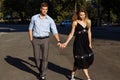 Happy couple, man and woman, over black background. hold hands, go and smile