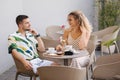 Happy couple of man and woman sitting in cafe and drink coffee Royalty Free Stock Photo
