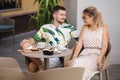 Happy couple of man and woman sitting in cafe and drink coffee Royalty Free Stock Photo