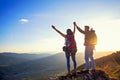 Happy couple man and woman tourist at top of mountain at sunset outdoors during a hike in summer Royalty Free Stock Photo