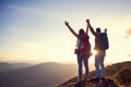 Happy couple man and woman tourist at top of mountain at sunset outdoors during a hike in summer Royalty Free Stock Photo