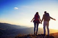 Happy couple man and woman tourist at top of mountain at sunset outdoors during a hike in summer Royalty Free Stock Photo