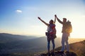 Happy couple man and woman tourist at top of mountain at sunset outdoors during a hike in summer Royalty Free Stock Photo