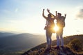 Happy couple man and woman tourist at top of mountain at sunset outdoors during a hike in summer Royalty Free Stock Photo