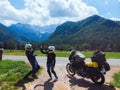 Happy couple of motorcyclists adventure bikers. Green meadow in Zgornje Jezersko, to Kamnik-Savinja Alps on a sunny summer day in