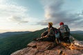 A happy couple in the mountains admires the beautiful views. A man and a woman with backpacks on the mountain admire the panoramic Royalty Free Stock Photo