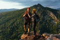 A happy couple in the mountains admires the beautiful views. Travelers enjoy climbing the mountain at sunset Royalty Free Stock Photo