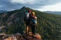 A happy couple in the mountains admires the beautiful views. Travelers enjoy climbing the mountain at sunset Royalty Free Stock Photo