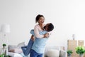 Happy couple moving at bought house, husband lifts up beloved wife, family begin new life at first dwelling Royalty Free Stock Photo