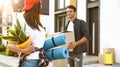 Happy couple with moving boxes and stuff near their new house on sunny day Royalty Free Stock Photo