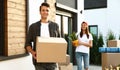 Happy couple with moving boxes and household stuff near their new house Royalty Free Stock Photo