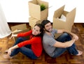 Happy couple moving together in a new house unpacking cardboard boxes