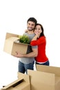 Happy couple moving together in a new house unpacking cardboard boxes