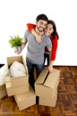 Happy couple moving together in a new house unpacking cardboard boxes