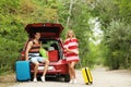 Happy couple near car trunk with suitcases outdoors Royalty Free Stock Photo